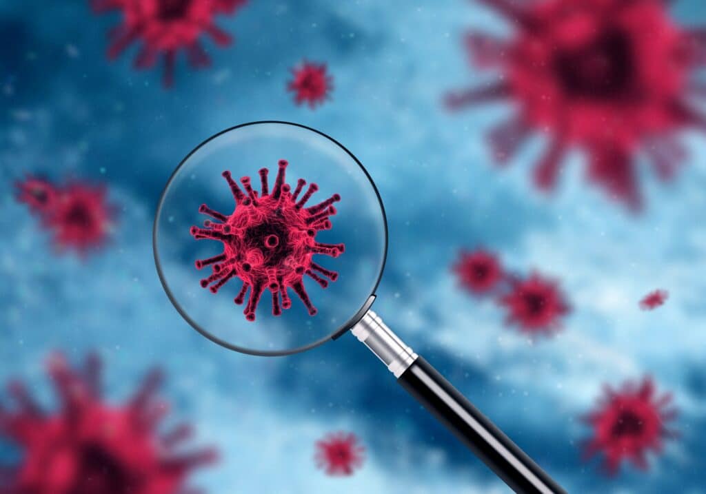 Modern biotechnology concept with magnifying glass over red virus bacteria
